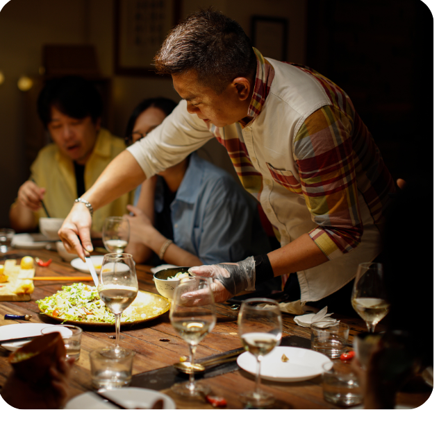Hospitality team serving guests around a shared table